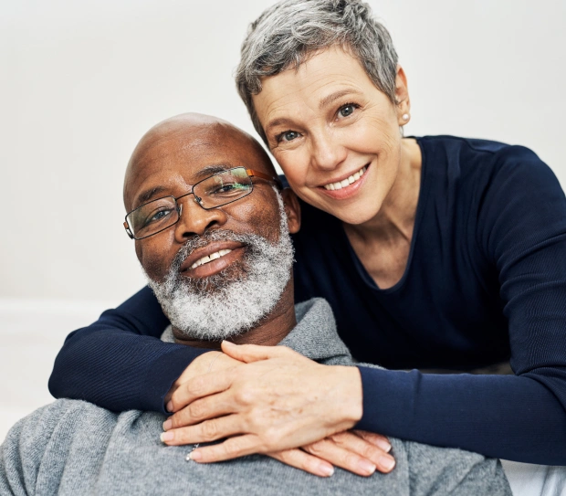 Smiling senior couple after receiving custom dentures